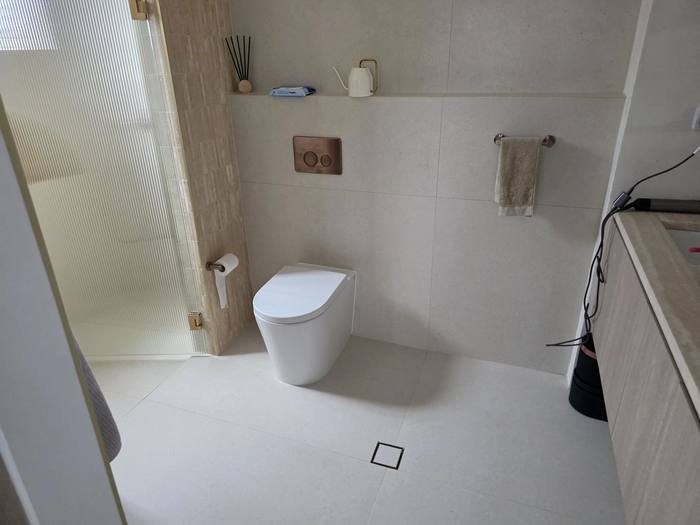 Ensuite bathroom fitout with wall-hung toilet and stone finishes